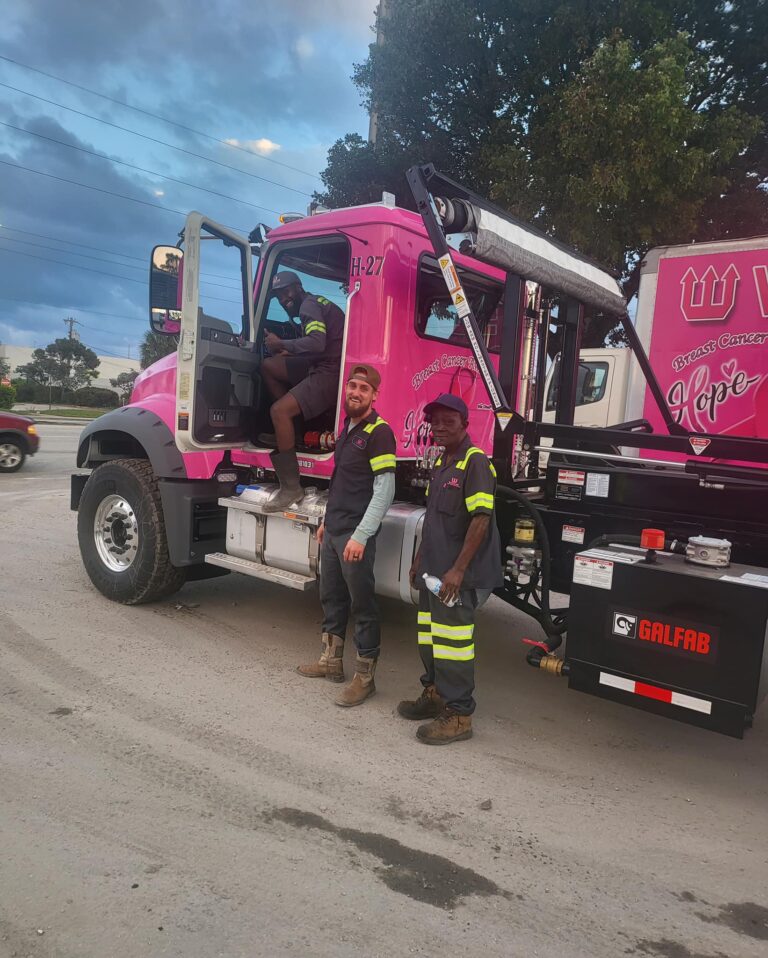 Wasteline Solutions truck drivers beside pink truck in work yard