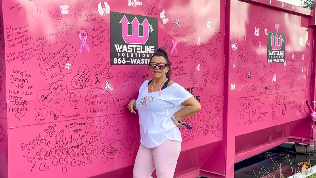 Mrs. Tina Goldstein standing next to pink dumpster supporting Breast Cancer Awareness | Wasteline Solutions
