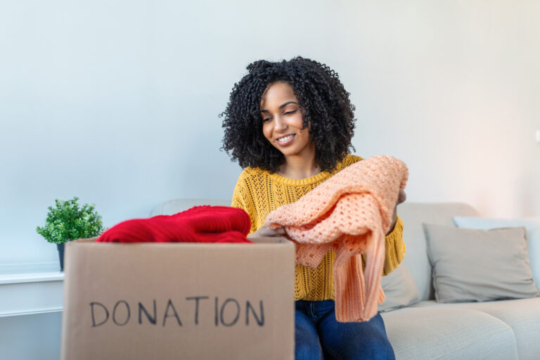 Woman decluttering home with donation box | Wasteline Blog