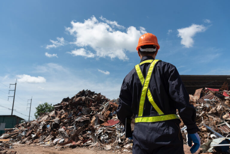 waste management worker standing in front of landfill