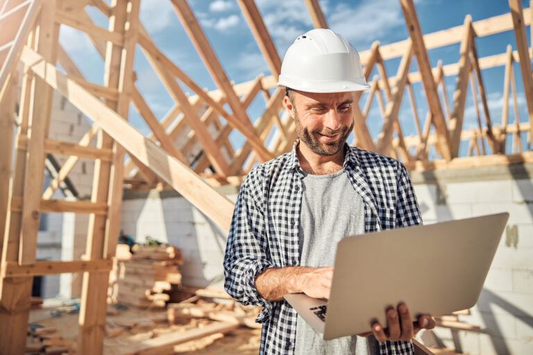 Contractor on job site looking at laptop | Wasteline Solutions Blog