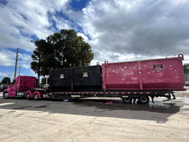 Wasteline Solutions Pink Dumpster Truck driving out of yard