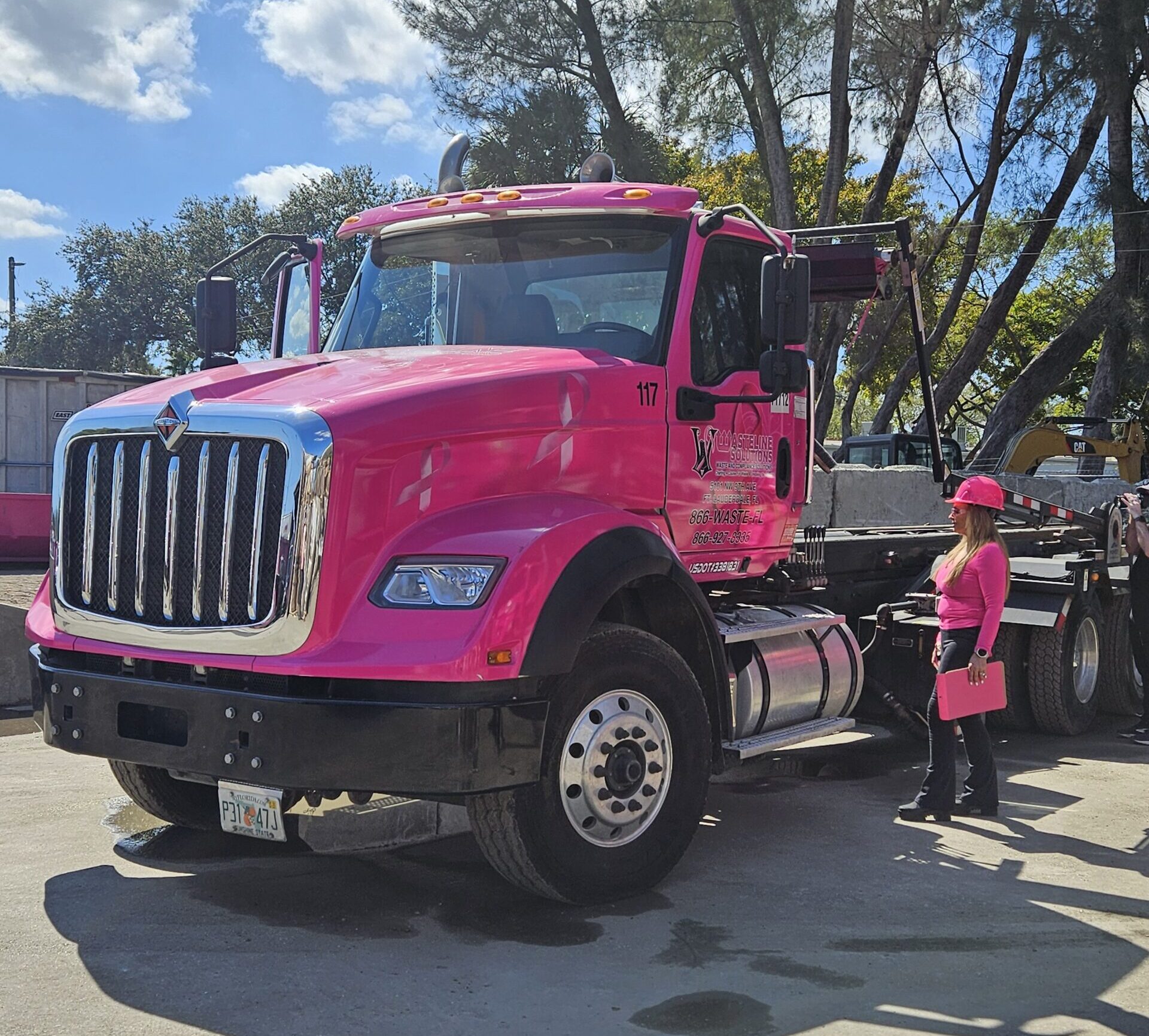 Wasteline Solutions Pink Truck in yard with Mrs. Tina Goldstein standing on side